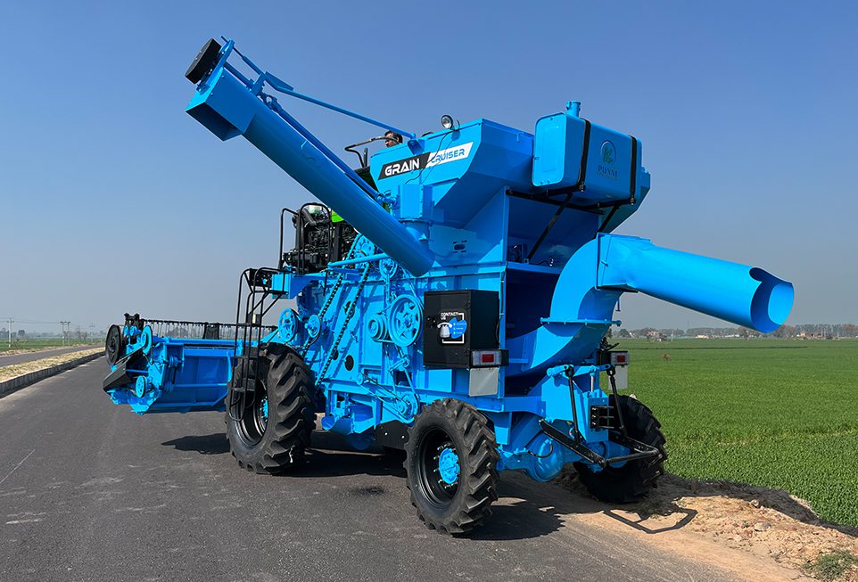 Front view of Punni Tractor Mounted Combine Harvester harvesting wheat in an open field.