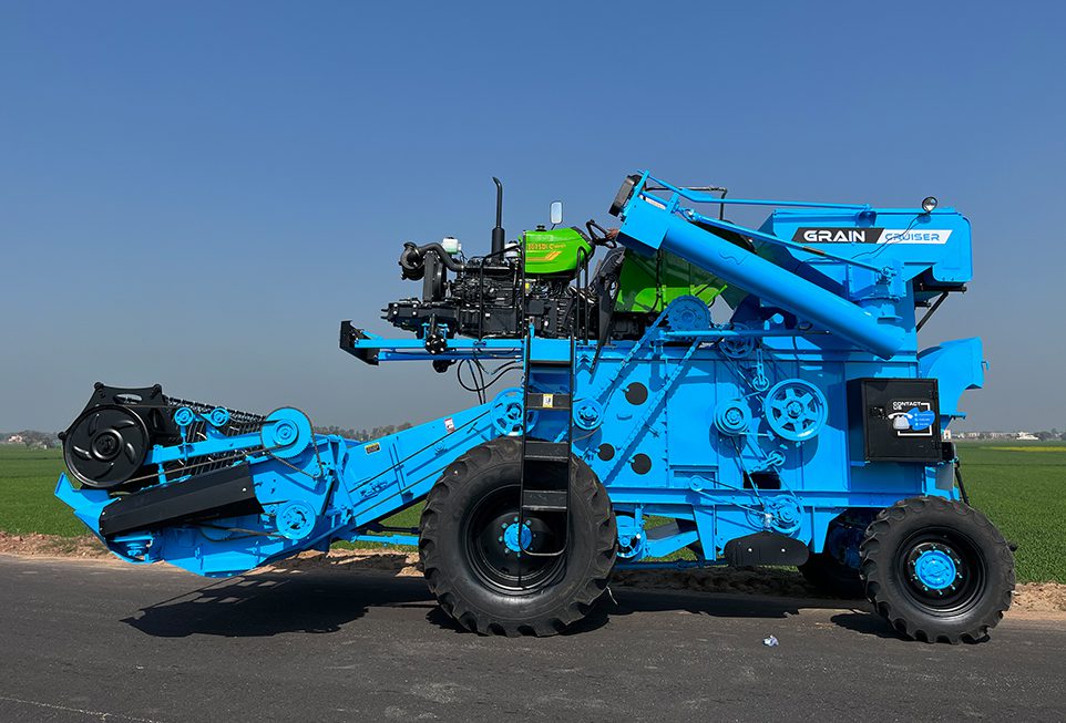 Rear view of combine harvester showing grain collection and discharge process.